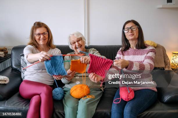 une femme âgée apprend à ses filles à tricoter - tricoté photos et images de collection