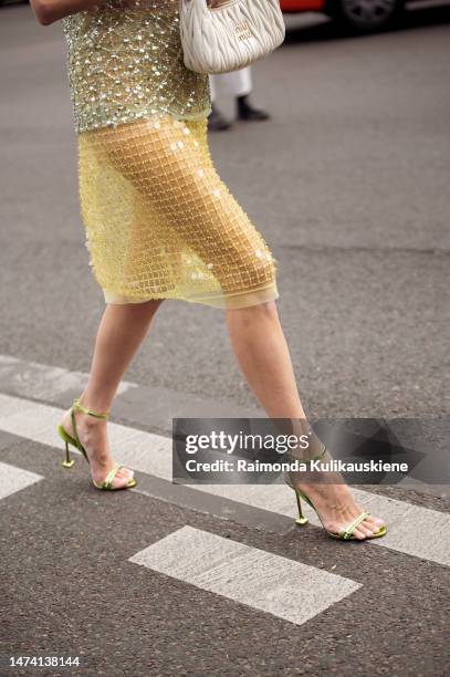 Leonie Hanne seen wearing a transparent green glitter top and yellow transparent glitter skirt with a white bag outside the Miu Miu show during Paris...