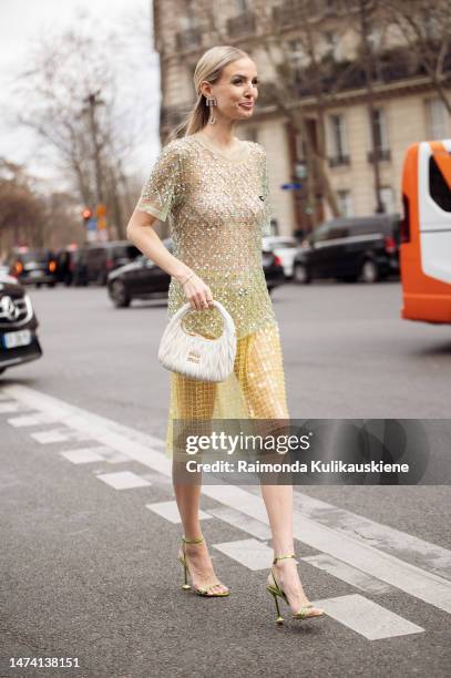 Leonie Hanne seen wearing a transparent green glitter top and yellow transparent glitter skirt with a white bag outside the Miu Miu show during Paris...