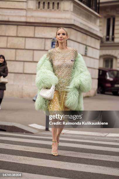 Leonie Hanne seen wearing a transparent green glitter top and yellow transparent glitter skirt with a white bag and a fluffy green coat outside the...