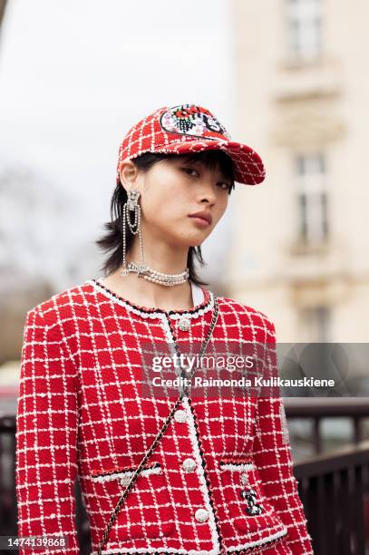 Sabrina Yaqian Lan wears a red checked Chanel jacket with matching pants, red Chanel hat, silver jewelry and black loafers, outside the Chanel show...