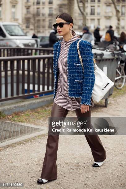 Julia Haghjoo seen wearing a blue tweed jacket, a striped blouse, brown leather pants a white bag, black shades and black and white ballet flats...