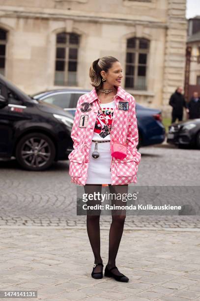 Helena Bordon seen wearing a pink and white patterned jacket, a white skirt, a printed shirt, black transparent tights, a pink bag, a choker and...