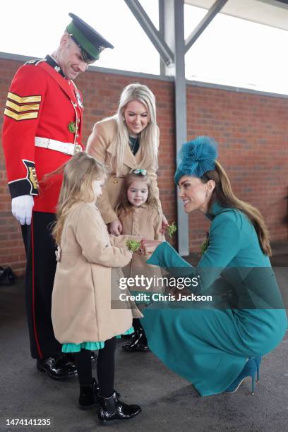 Catherine, Princess of Wales presents a traditional sprig of shamrock to an Officers children during the St. Patrick's Day Parade at Mons Barracks on...