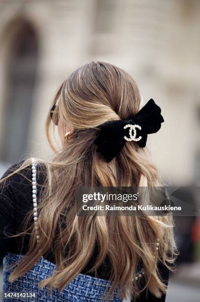 Paola Alberdi seen wearing a blue tweed jumpsuit, a black turtle neck sweater, a black belt bag and a black and beige bag by Chanel, black shades and...