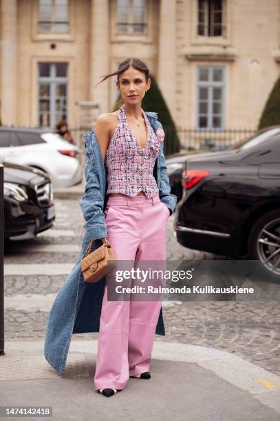 Dani Schulz is seen wearing pink wide leather pants, pink, white and blue tweed Chanel vest, long deniim coat and beige Chanel bag outside the Chanel...