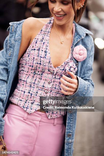 Dani Schulz is seen wearing pink wide leather pants, pink, white and blue tweed Chanel vest, long deniim coat and beige Chanel bag outside the Chanel...