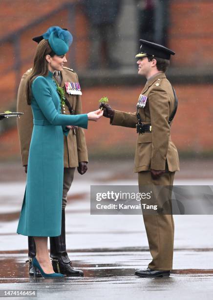 Catherine, Princess of Wales presents a traditional sprig of shamrock to an Officer during the St. Patrick's Day Parade at Mons Barracks on March 17,...