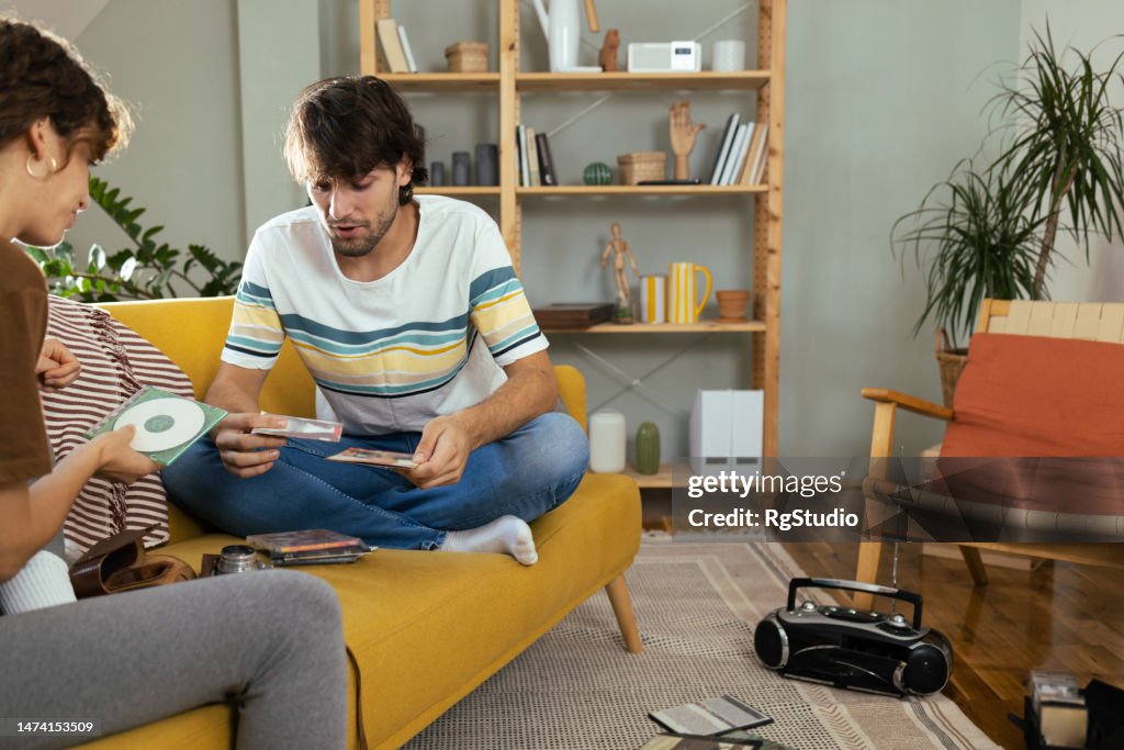 Young couple playing retro music on a cd player