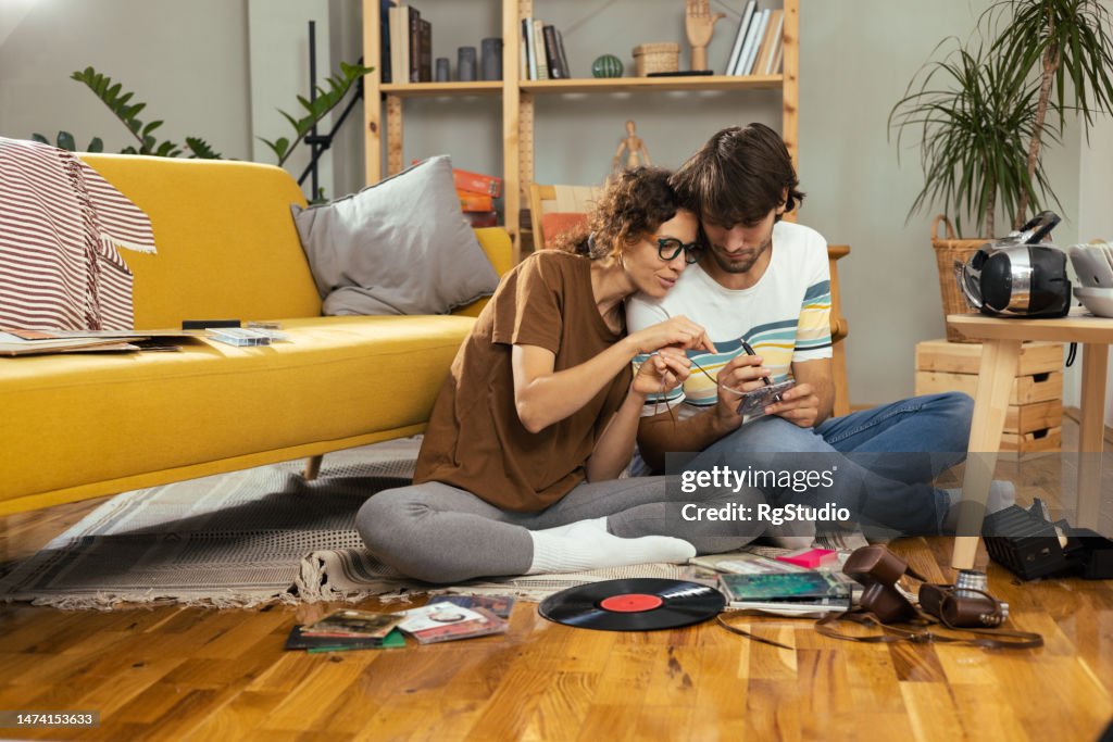 Young couple enjoying at home and searching for some old music discs to play them