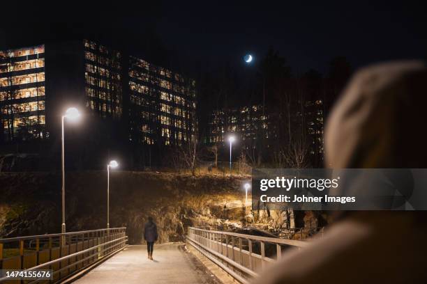people on footbridge at night - violencia fotografías e imágenes de stock