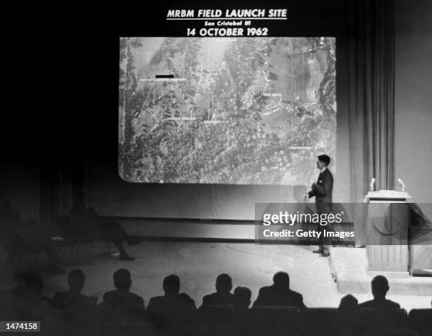 John Hughes, Special Assistant to the Director of Defense Intelligence, conducts a military briefing for the news media showing the absence of Soviet...