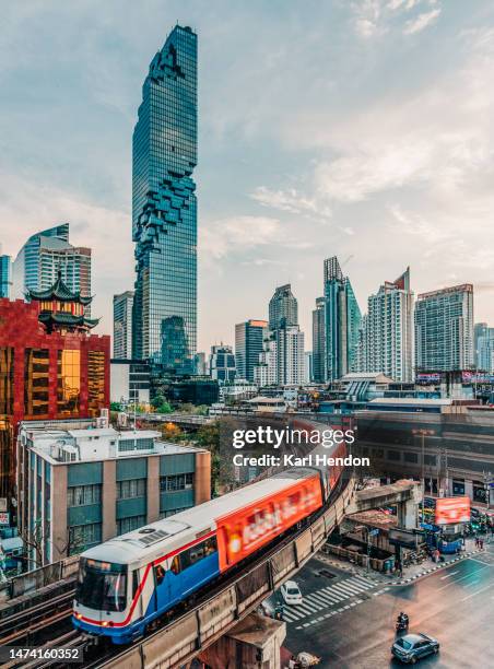 a train on an elevated track in bangkok, thailand - bangkok stock-fotos und bilder