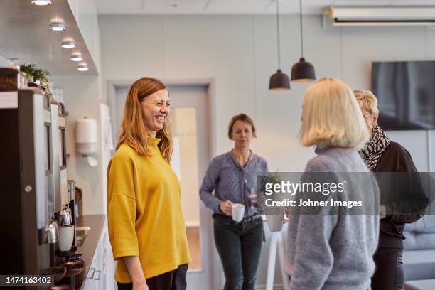 women talking in office kitchen - coffee break office stock pictures, royalty-free photos & images
