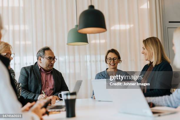 smiling people talking in office - 40 50 business woman stock pictures, royalty-free photos & images