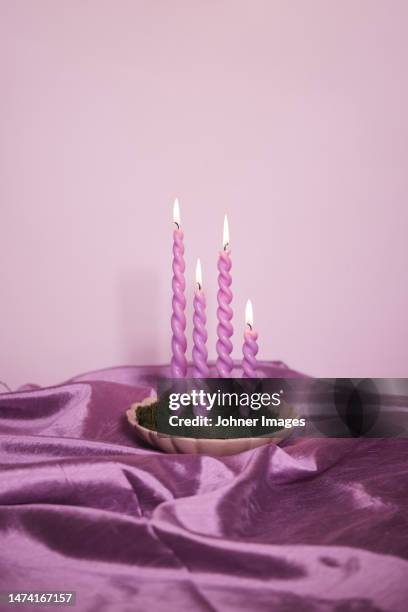 pink candles on satin fabric - lit satin stock-fotos und bilder