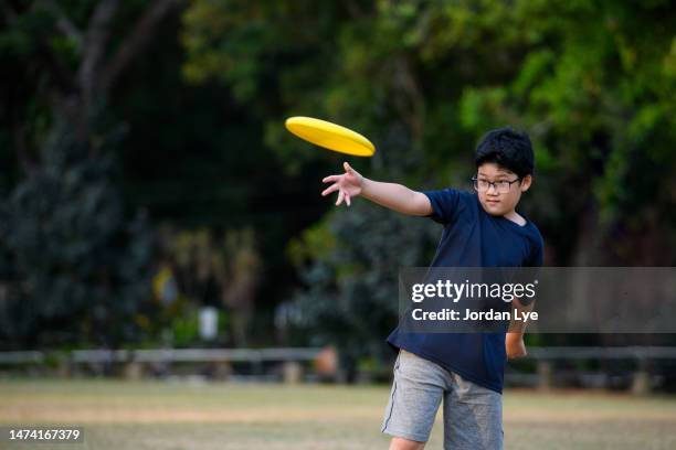 little boy plays frisbee in park - disc golf stock pictures, royalty-free photos & images