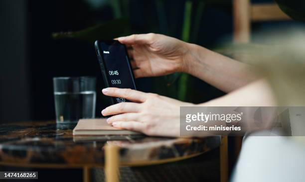close up of woman hands snoozing alarm on a mobile phone screen in the morning - alarm clock hand stock pictures, royalty-free photos & images