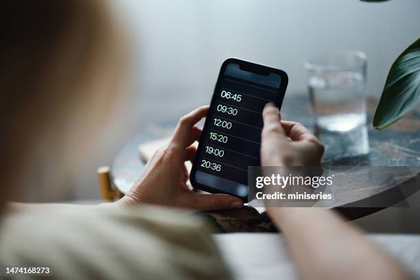 close up of woman hands snoozing alarm on a mobile phone screen in the morning - woman sleeping table stock pictures, royalty-free photos & images