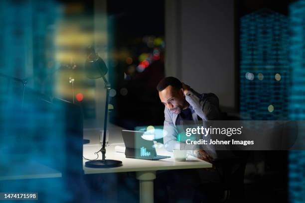 young businessman working in office at night - recessed lighting fotografías e imágenes de stock