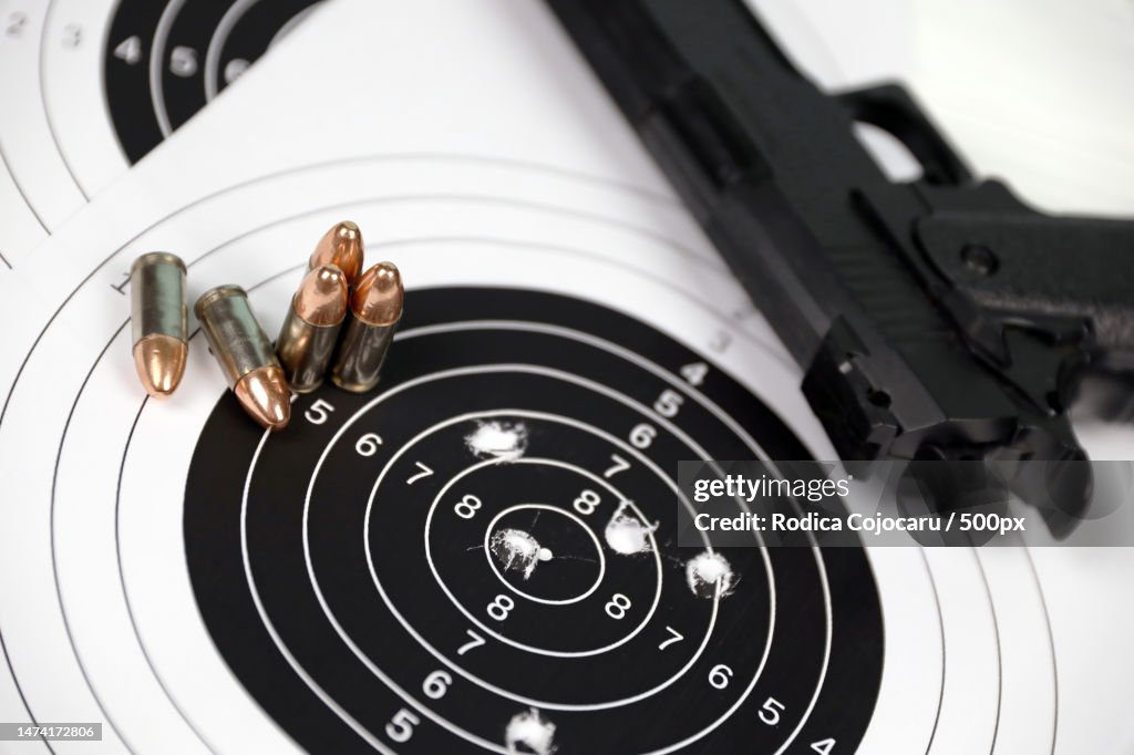 Gun And Many Bullets Shooting Targets On White Table In Shooting Range ...