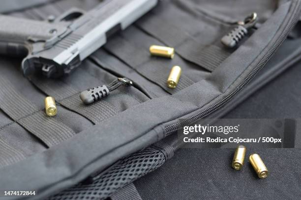 9mm bullets and pistol lie on a black tactical backpack - vingança imagens e fotografias de stock