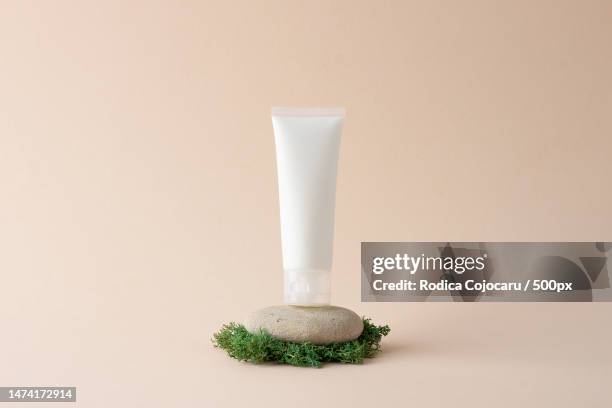 white tube of cosmetic cream on a stone podium with moss on beige background close up,romania - conditioner imagens e fotografias de stock