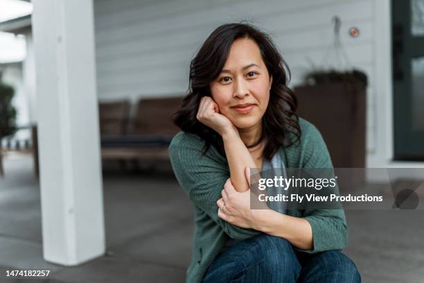 woman sitting on front step of home - mature women portrait asian bildbanksfoton och bilder