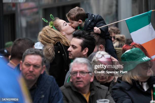Woman kisses a child while watching the St. Patrick's Day Parade along 5th Ave. On March 17, 2023 in New York City. Known as the world's largest St....