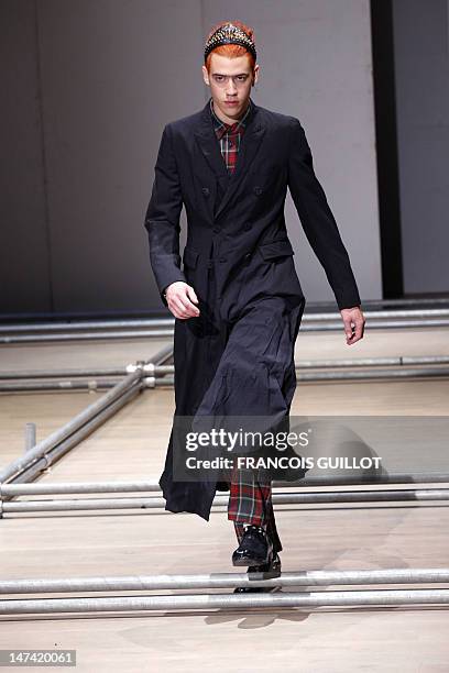 Model displays creations by Japanese designer Rei Kawakubo for the Comme des Garcons fashion house during the men's spring-summer 2013 fashion...