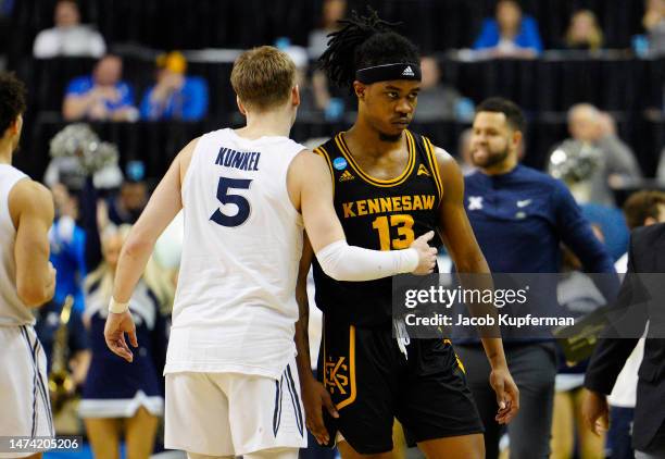 Kasen Jennings of the Kennesaw State Owls looks dejected while embracing Adam Kunkel of the Xavier Musketeers after being defeated by the Xavier...