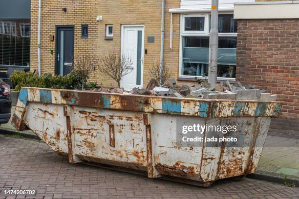 weathered rusty industrial construction waste container placed outside on the street - disposal container stock pictures, royalty-free photos & images
