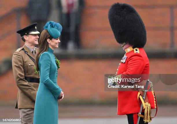 Catherine, Princess of Wales presents a traditional sprig of shamrock to an Officer during the St. Patrick's Day Parade at Mons Barracks on March 17,...