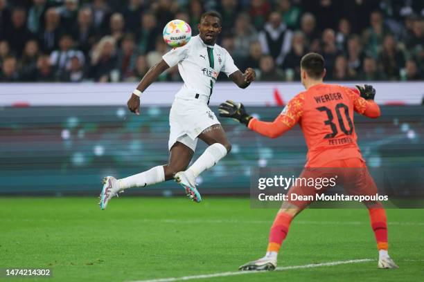 Marcus Thuram of Borussia Moenchengladbach has a headed shot as Michael Zetterer of SV Werder Bremen looks on during the Bundesliga match between...