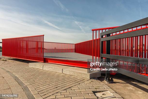 front view of a metal grid platform with red fencing - railing stockfoto's en -beelden