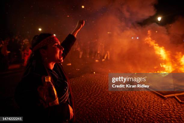 Protester chants and sings in front of a burning barricade at Place de la Concorde as demonstrations continue for a second straight night against the...