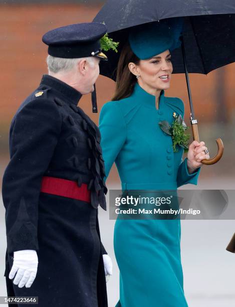 Catherine, Princess of Wales shelters under an umbrella as she attends the 2023 St. Patrick's Day Parade at Mons Barracks on March 17, 2023 in...