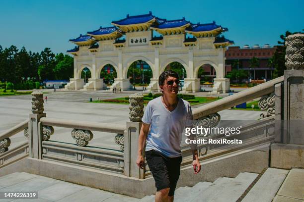 tourist man visiting chiang kai-shek memorial hall in taipei on a sunny day - taipei landmark stock pictures, royalty-free photos & images