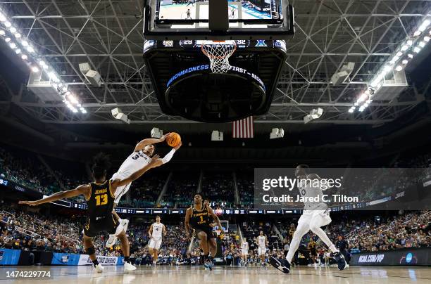 Colby Jones of the Xavier Musketeers passes the ball to teammate Souley Boum against Kasen Jennings of the Kennesaw State Owls during the first half...