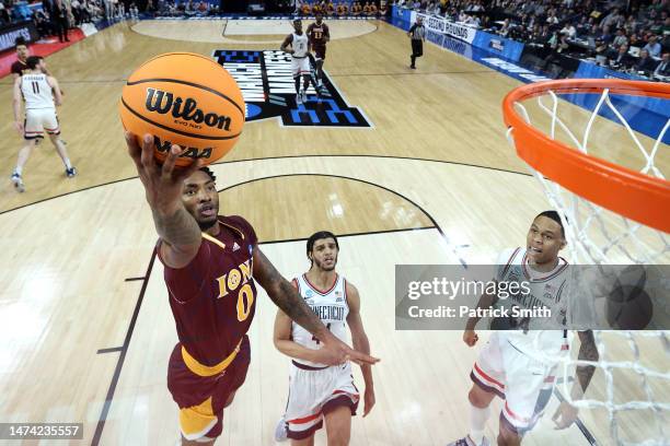 Berrick JeanLouis of the Iona Gaels drives to the basket against Andre Jackson Jr. #44 and Jordan Hawkins of the Connecticut Huskies during the first...