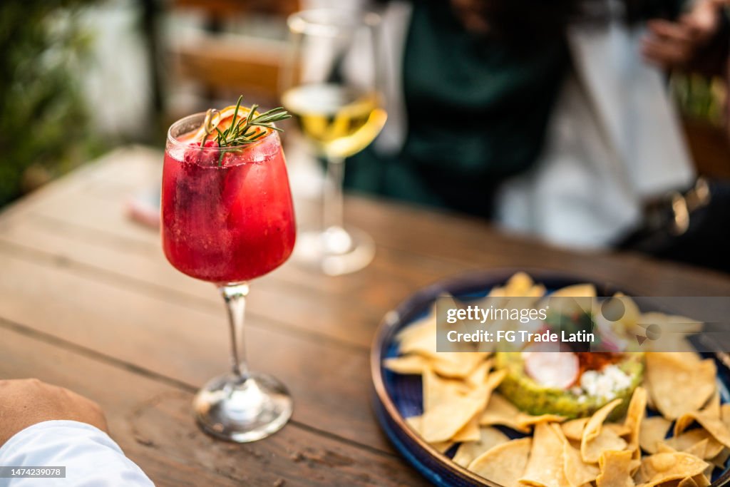 Close-up of cocktail and nachos at restaurant