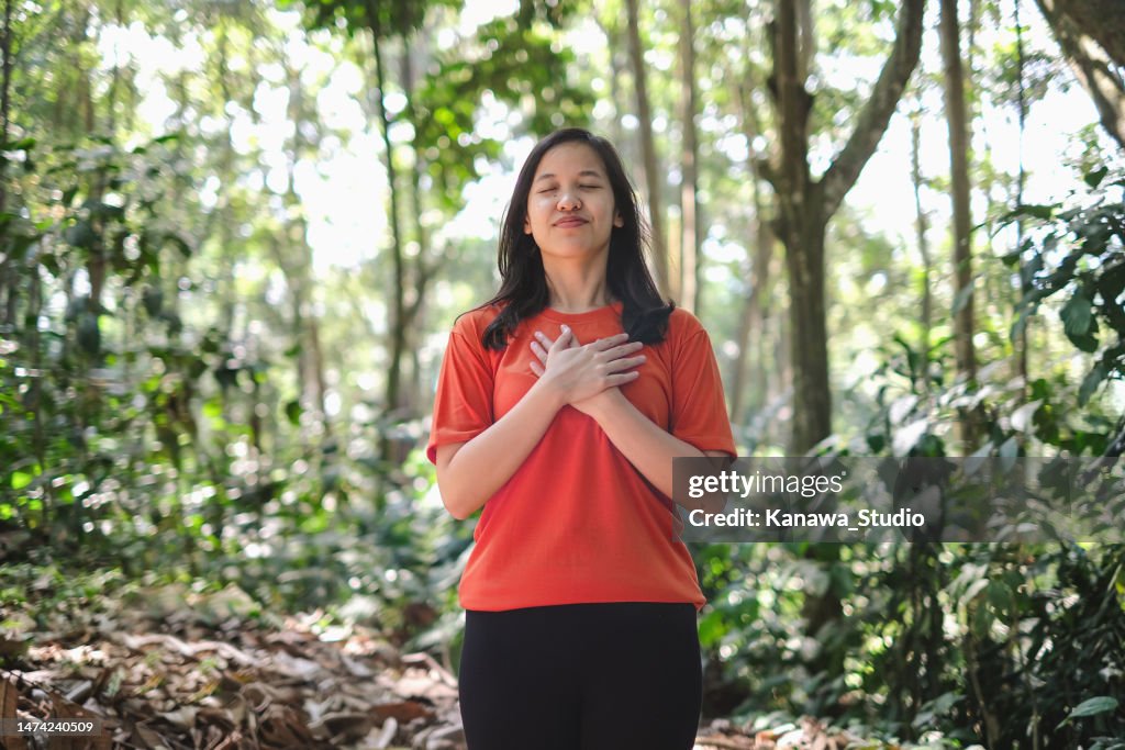 Young Asian Woman Meditating in Nature