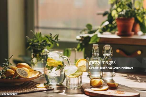 lemonade in glass and bottle on wooden table outdoors. summer refreshing drink. cold detox water with lemon - infused water stock pictures, royalty-free photos & images