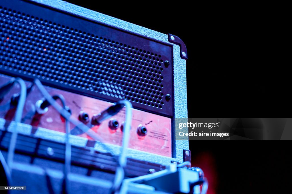 Low angle view of side view of audio amplifier and cables on a darkness background