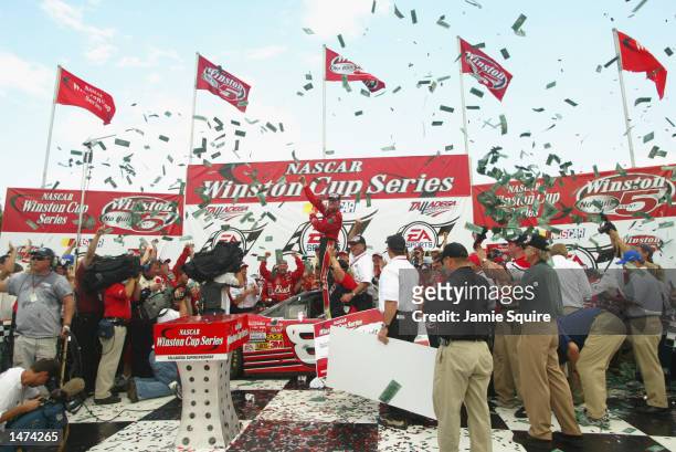 Dale Earnhardt, Jr., driver of the Budweiser Chevrolet Monte Carlo, celebrates in victory lane after winning the NASCAR Winston Cup EA Sports 500 at...