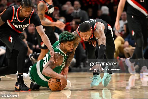 Marcus Smart of the Boston Celtics and Damian Lillard of the Portland Trail Blazers go after a loose ball during the fourth quarter at the Moda...