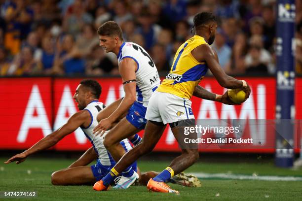 Liam Ryan of the Eagles evades Aiden Bonar of the Kangaroos and Harry Sheezel of the Kangaroos to kick a goal during the round one AFL match between...