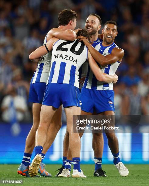 Nick Larkey of the Kangaroos hugs Charlie Comben , Griffin Logue and Aiden Bonar of the Kangaroos after winning the round one AFL match between North...