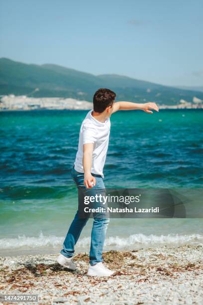 the guy throws stones into the sea - throwing rocks stock pictures, royalty-free photos & images