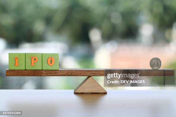 ipo blocks and rupee coin on seesaw - ipo stock pictures, royalty-free photos & images